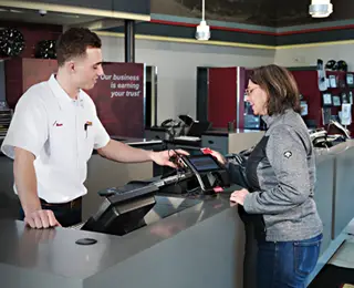 A Les Schwab employee helping a customer with their credit card