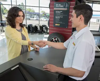 A Les Schwab technician shakes hands with a customer.