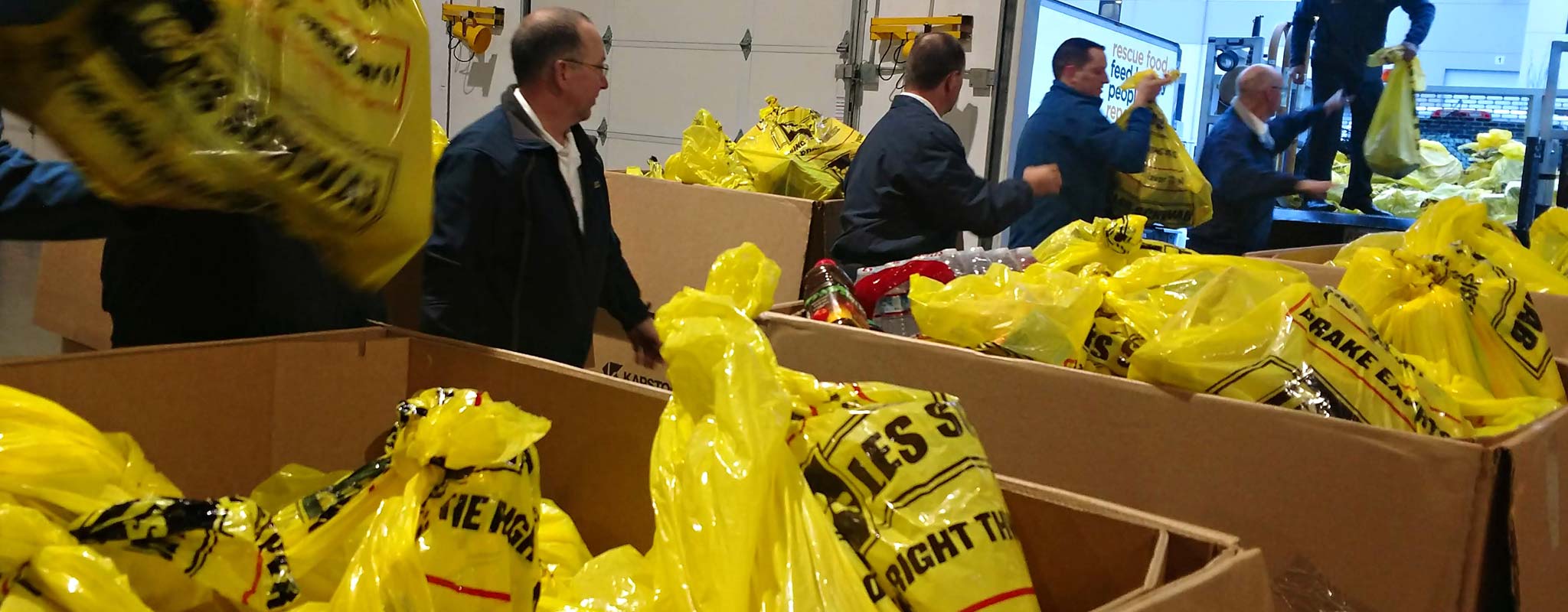 Les Schwab employees transferring collected food to a vehicle for delivery.