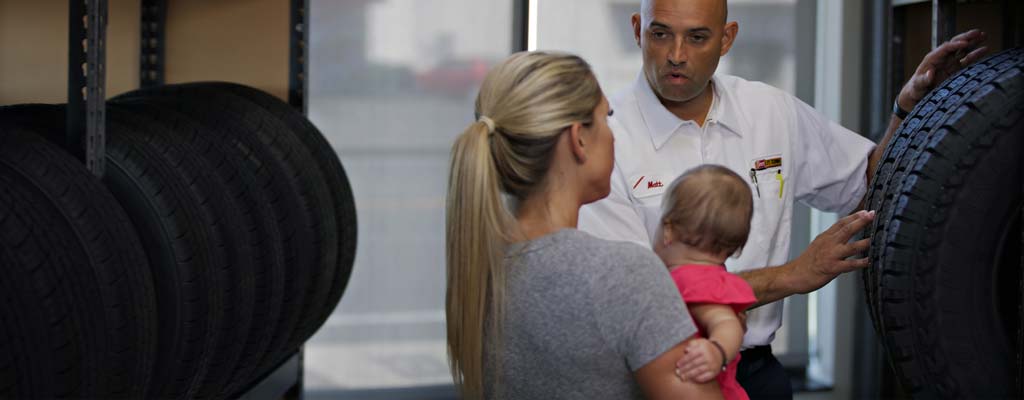 Les Schwab employee teaching a customer about tires.