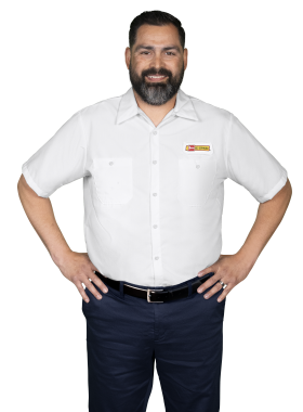 A Les Schwab technician stands arms akimbo. His name is Juan