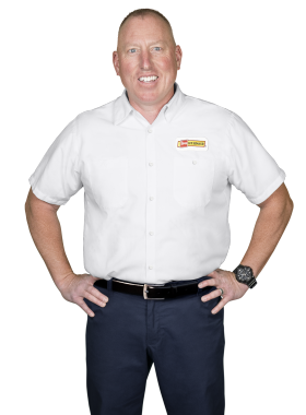 A Les Schwab technician stands arms akimbo. His name is Nate